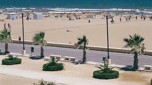 Una playa con gente, sombrillas y palmeras.