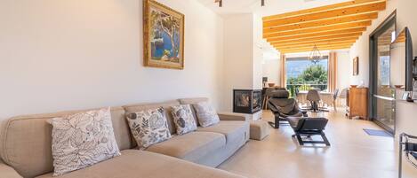 A modern living room with a sofa, a ceiling fan, and a painting on the wall.