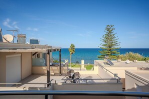 Une terrasse sur le toit offrant une vue sur la mer, équipée d’antennes paraboliques et de mobilier d’extérieur.