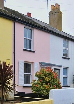 Rows of charming houses with pastel-colored facades and traditional tile roofs line the street.