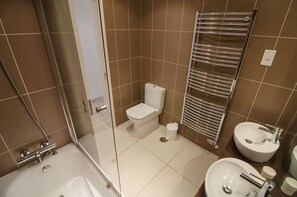 Een bad/douchecombinatie, een haardroger, handdoeken, toiletpapier