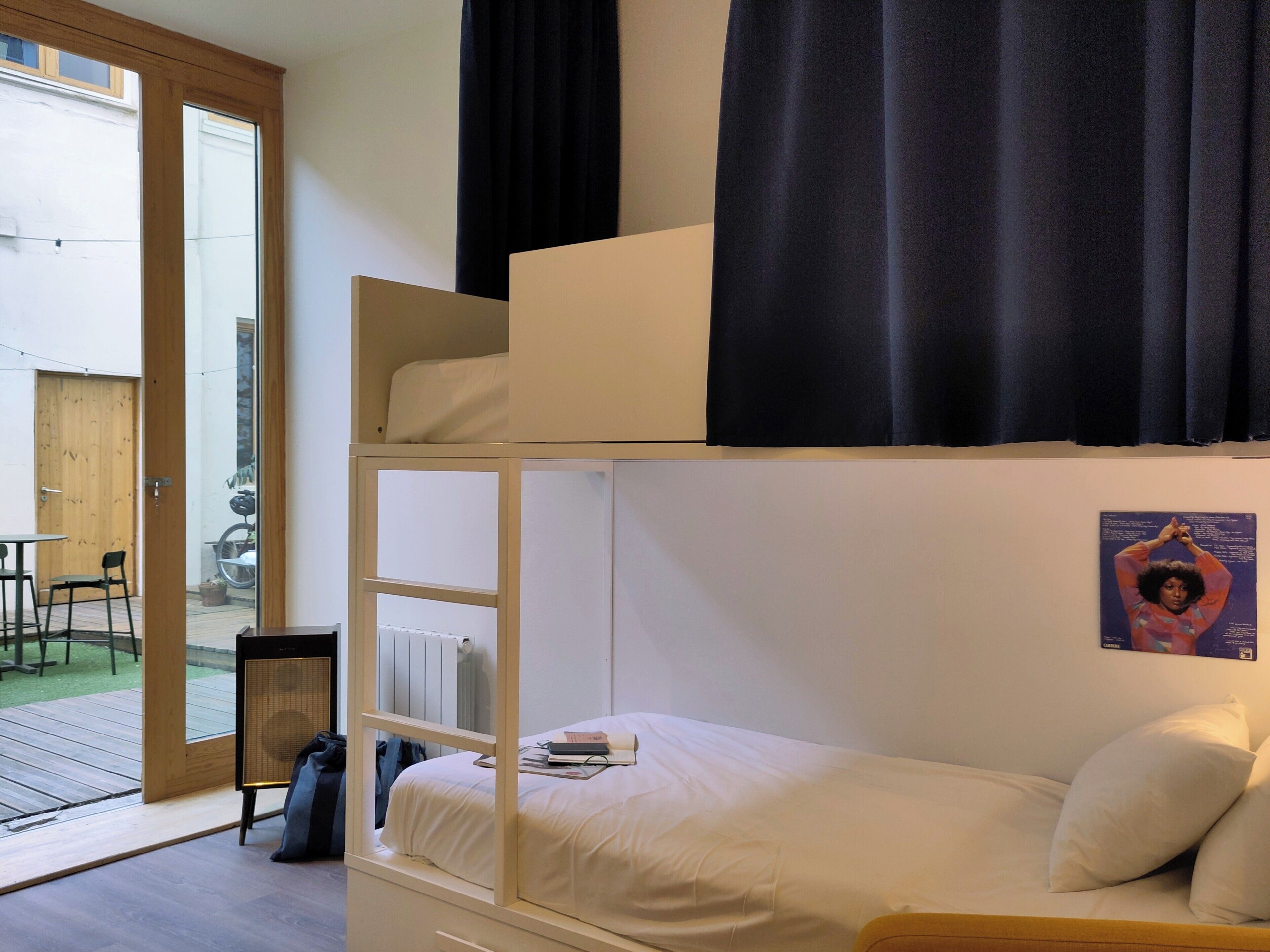 A bunk bed with a lower bunk, a small table, and a chair.