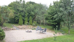 A gravel patio with a fire pit, outdoor seating, and a stone wall. - Enjoy the tranquility of nature, - / juniper reserve in Alendorf (Blankenheim /Alendorf)