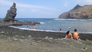 A rocky beach with people sunbathing and swimming. - CASA AURA sunshine over the sea (Hermigua la gomera)