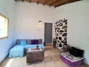 A cozy room with a sofa, a small wooden table, and a cushioned bench. - CASA AURA sunshine over the sea (Hermigua la gomera)
