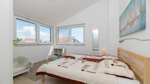 Une chambre à coucher avec un lit, une chaise, une étagère et un tableau.