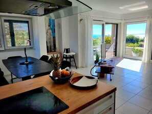 Una cucina moderna con zona pranzo, ampie finestre e vista sull'esterno.