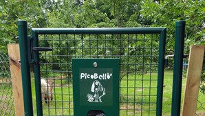 Un cancello verde in metallo con il logo Picabello, circondato da una recinzione a maglie e erba.