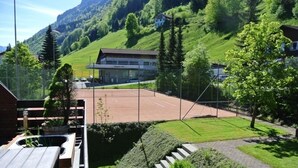 Ein Hotel mit modernem Design, einem Parkplatz und Blick auf eine Berglandschaft.