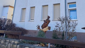 A multi-story building with a row of windows and a wooden sculpture in front. - New Feriewohnung in the heart of the valley with stunning view to Roßtrappe, **** (Thale)