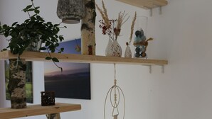 A multi-tiered wooden shelf unit with various decorative items, including a lantern, glass jars, and a hanging ornament. - Brunow vacation apartment "At home in nature" (Neundorf)