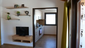 Una cocina moderna con armarios de madera, horno empotrado y ventana con vistas.