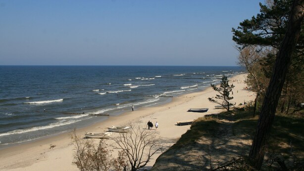 A beach with boats on the shore, a clear sky, and a few people walking. - Comfortable vacation apartment in Zempin - beach vacation on Usedom with your dog (Zempin)