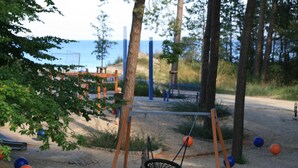 A playground with a swing set, sand, and trees. - Comfortable vacation apartment in Zempin - beach vacation on Usedom with your dog (Zempin)