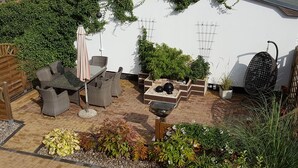 A patio with wicker furniture, a table, and a grill. - Comfortable vacation apartment in Zempin - beach vacation on Usedom with your dog (Zempin)