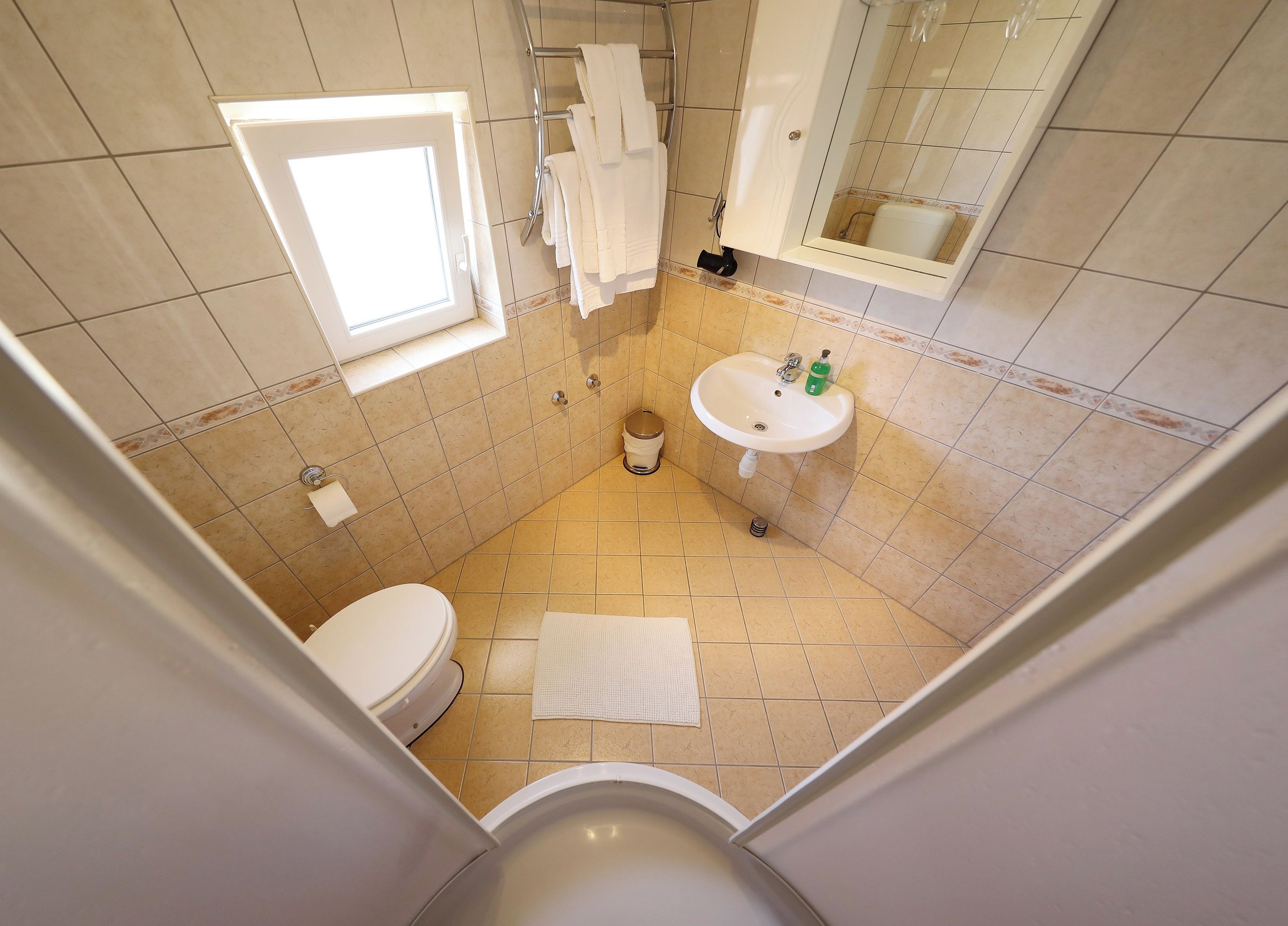 Un baño pequeño con inodoro, lavamanos y ventana.