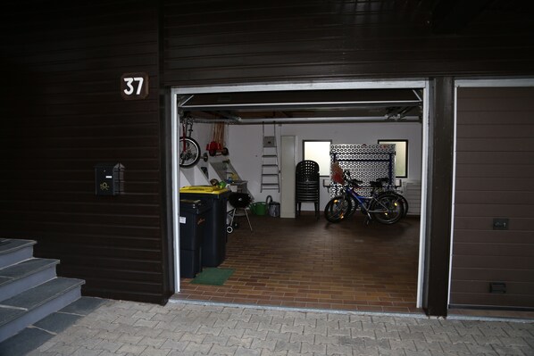 A garage with a bicycle, a red toy car, and a ladder.