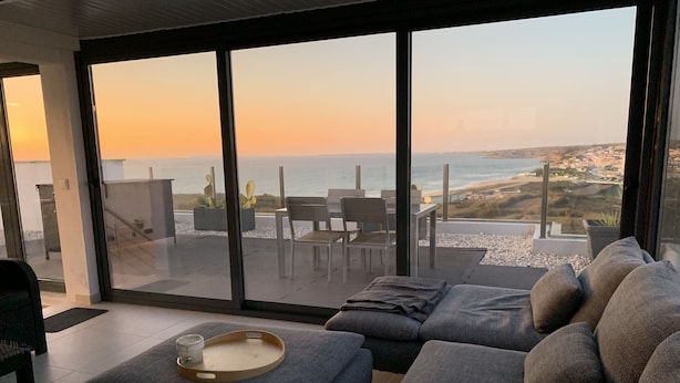 A modern living room with a large sliding glass door leading to an outdoor patio.