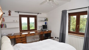 A bedroom with a bed, a desk with a computer, a chair, and shelves with books. - DOLCI COLLINE Villa on the hills - POOL, 50min from ROME (Moricone)
