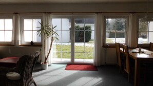 Comedor con una mesa, sillas y un ventanal con vistas a un jardín.