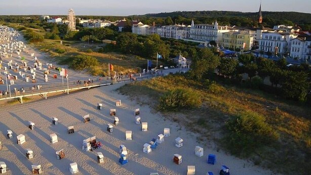 Een strand met tal van kleine, witte, tentachtige constructies in rijen.