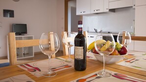 A dining table with a bottle of wine, two wine glasses, and a bowl of fruit. - 3-room apartment to 6 persons with balcony  (Domaso)