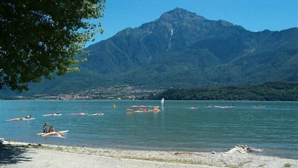 A lake with several boats, a sandy beach, and a mountain in the background. - 3-room apartment to 6 persons with balcony  (Domaso)