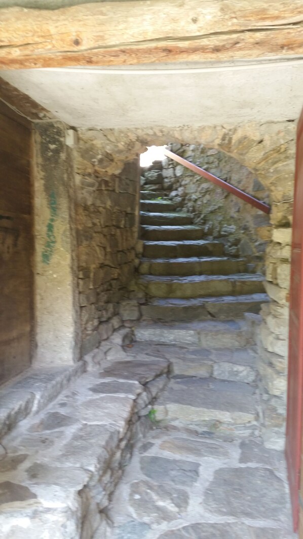 Una scala in pietra che conduce a una porta in legno.