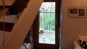 A wooden staircase leading to a door with a view of a forest.