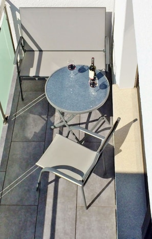 A small round table with two wine glasses and a bottle on a balcony. - Maisonette charming apartment, near bike and. Hiking trails in the Nassau / Limburg nature park (Altendiez)