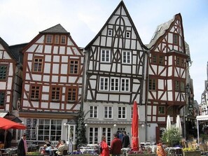 Traditional inn with timber framing and multiple windows, offering outdoor seating and dining areas.