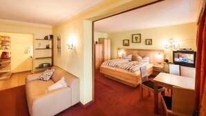 Een hotelkamer met een bed, een bureau, een stoel, een bank en een televisie.