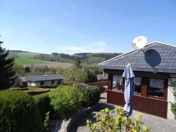 A building with a satellite dish, wooden deck, and a view of the countryside.