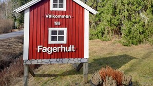 A red wooden building with white trim, labeled 'Välikommen Till Fagerhult.'
