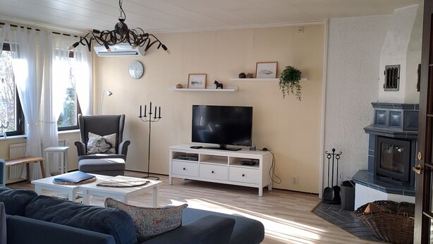 A living room with a sofa, TV, white cabinets, and a fireplace.