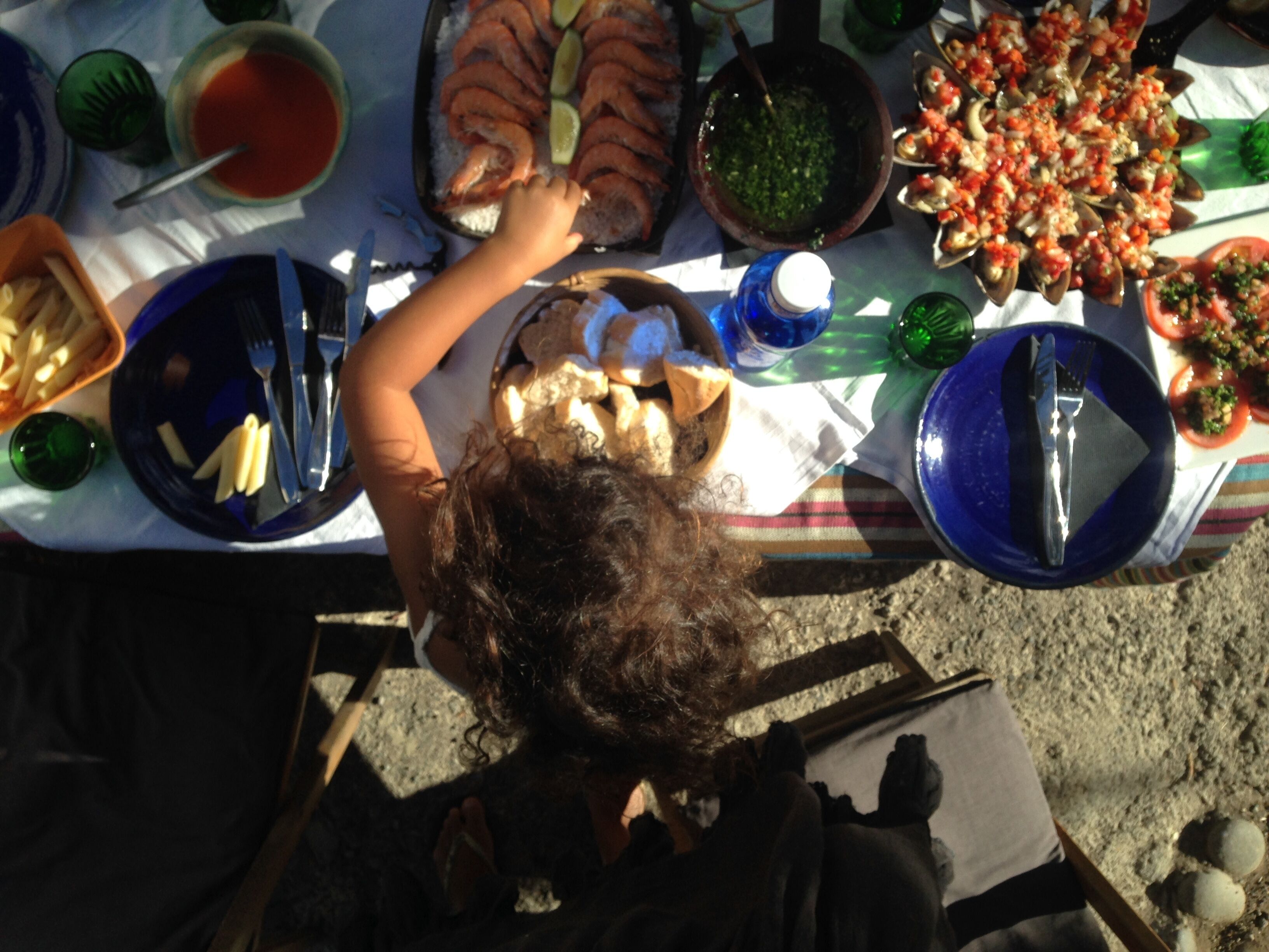 A dining table with various dishes, including seafood and pasta, set for a meal.