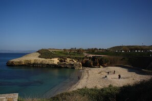 Una playa cerca, sillas reclinables de playa, toallas de playa