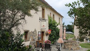 An outdoor seating area with stone tables and chairs, a stone wall, and a sign for 'Kunstcafe Maxen'. - Apartment in historic surroundings (Müglitztal)