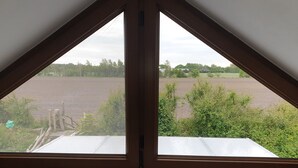 Una habitación con un ventanal grande con vistas a un campo.