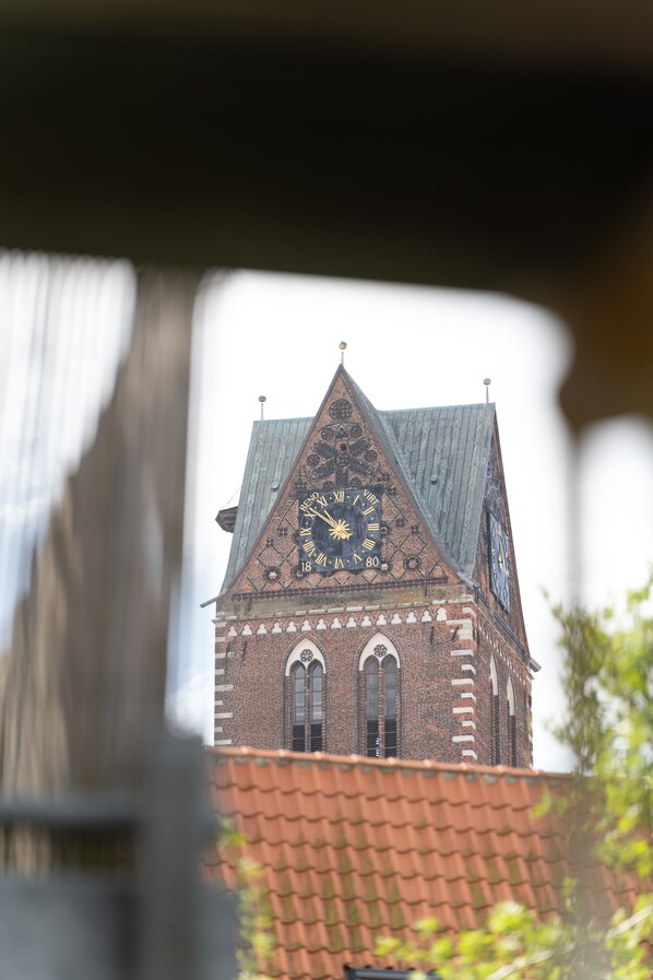 A building with a clock tower and a red-tiled roof. - 3 stars (DTV) 50m ² guest apartment between port and. old town (Wismar)