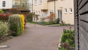 Eine Wohnstraße mit Häusern, einem Kirchturm und einem gepflasterten Gehweg.