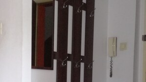 A room with a white cabinet, a mirror, and a wall-mounted telephone.