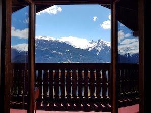 A room with a large window overlooking snow-capped mountains. - Historic mountain farm in the Montafon (Schruns)