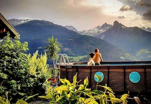 Una piscina con vistas a montañas, rodeada de vegetación.