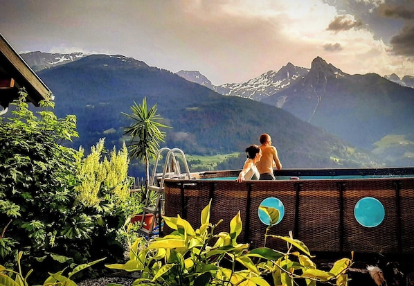 A swimming pool with a view of mountains, surrounded by greenery. - Historic mountain farm in the Montafon (Schruns)