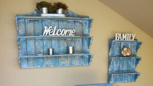 A blue wooden wall decoration with 'Welcome' and 'Family' signs.