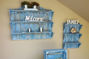 A blue wooden wall decoration with 'Welcome' and 'Family' signs.