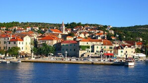 A coastal town with historic buildings, a prominent church, and a marina with boats.