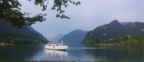 A boat on a calm lake surrounded by mountains.