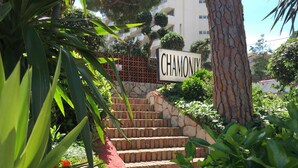 A sign reading "CHAMONX" above a set of brick stairs surrounded by greenery.